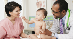 A nurse and a pediatrician examine a baby